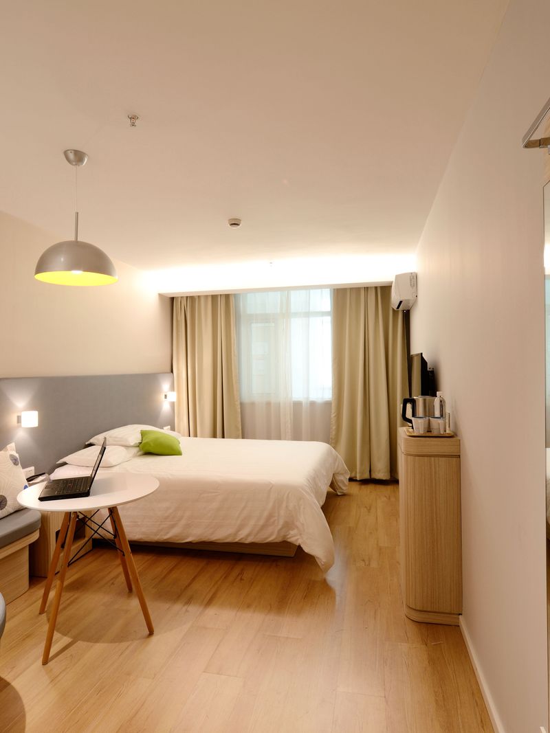 Hotel bedroom with made bed and warm lighting